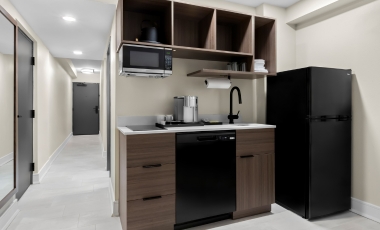 A small hotel kitchenette featuring a refrigerator, microwave, and sink, located near Twin Lights Historic Site.