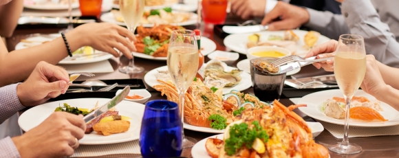 A group of diverse people enjoying a meal together at a restaurant near Victory Stables, highlighting local dining options.