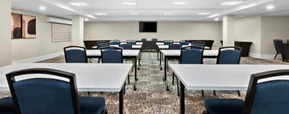 A conference room featuring tables and chairs, set up for events at the Hotel Near Sea Girt Lighthouse.