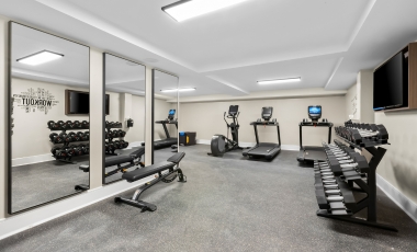 A fitness center featuring mirrors and various exercise equipment, located in a hotel near Sea Girt Lighthouse.