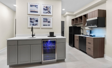 A well-equipped kitchen with a refrigerator, microwave, and sink, designed for convenience at the hotel near Twin Lights State Historic Site.
