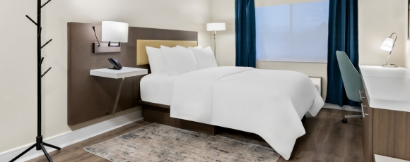 Comfortable hotel room with a bed, desk, and chair, perfect for travelers near Twin Lights State Historic Site.