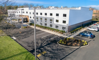 Exterior view of the Latitude Suites, featuring contemporary design and landscaping with Free Self-Parking.