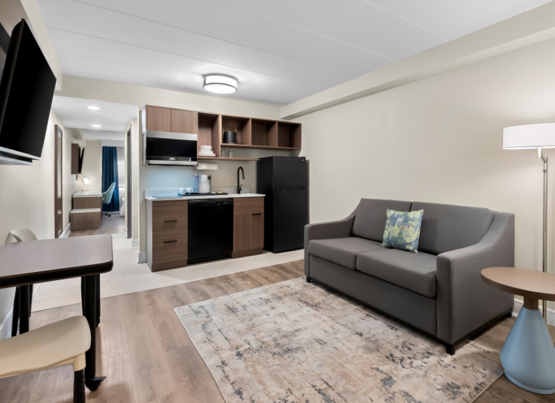 Cozy living room with a couch, table, and refrigerator, located in the Hotel Near Park Loft.