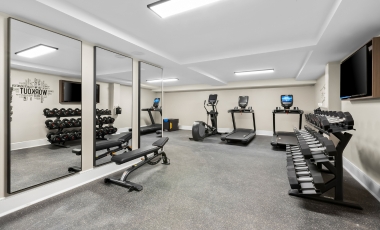 A fitness room featuring mirrors and various exercise equipment at Hotel Near Park Loft.