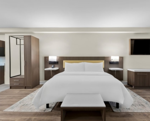 A hotel room featuring a bed, desk, and television, located near Shadowbrook at Shrewsbury.