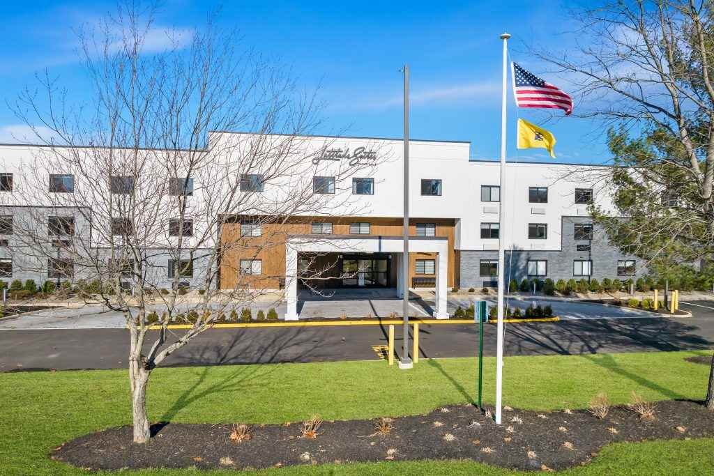 Latitude Suites welcomes guests with a modern exterior, convenient covered drop-off, and well-kept landscaping, offering a comfortable and accessible stay for business, medical, and extended-stay travelers.