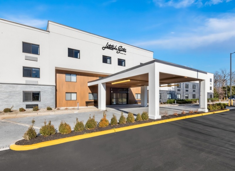 Hotel-Near-Capelli-Sports-Center-2 A daytime exterior view of Latitude Suites featuring the main entrance and modern design, offering a convenient stay for teams and families visiting Capelli Sports Center.