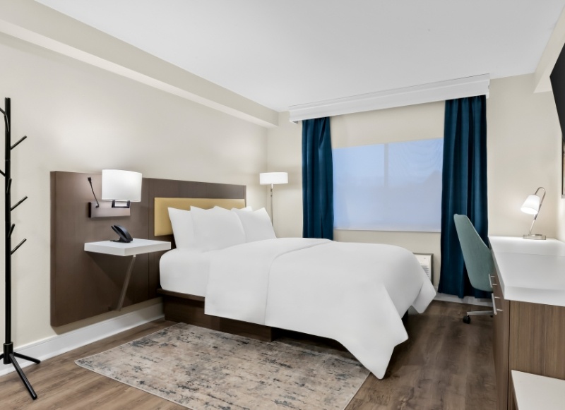 Hotel room featuring a bed, desk, and television, located near the Count Basie Center for the Arts.