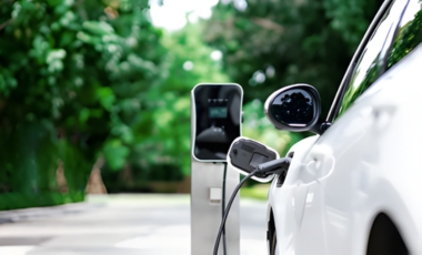 An electric car charging at a station outside a hotel near Eatontown, NJ, promoting electric vehicle accessibility.