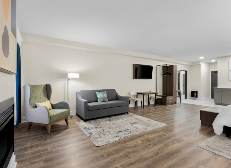 Hotel-Near-Hackensack-University-Medical-Center-NJ-1 Hotel room featuring a bed, couch, and television, located near Hackensack University Medical Center, NJ.