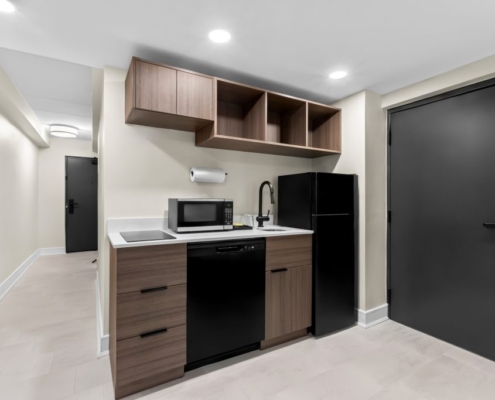 Hotel kitchen with fridge, microwave, sink near MetLife Stadium.