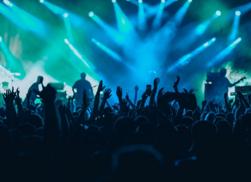 Concert crowd with hands raised at PNC Bank Arts Center.
