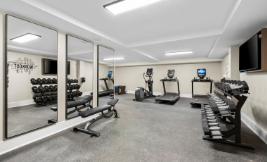 A fitness room featuring mirrors and various exercise equipment at a hotel near Paramount Theatre, Asbury Park.