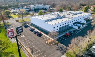 Exterior view of a suburban hotel, featuring free parking and proximity to St. Barnabas Hospital.