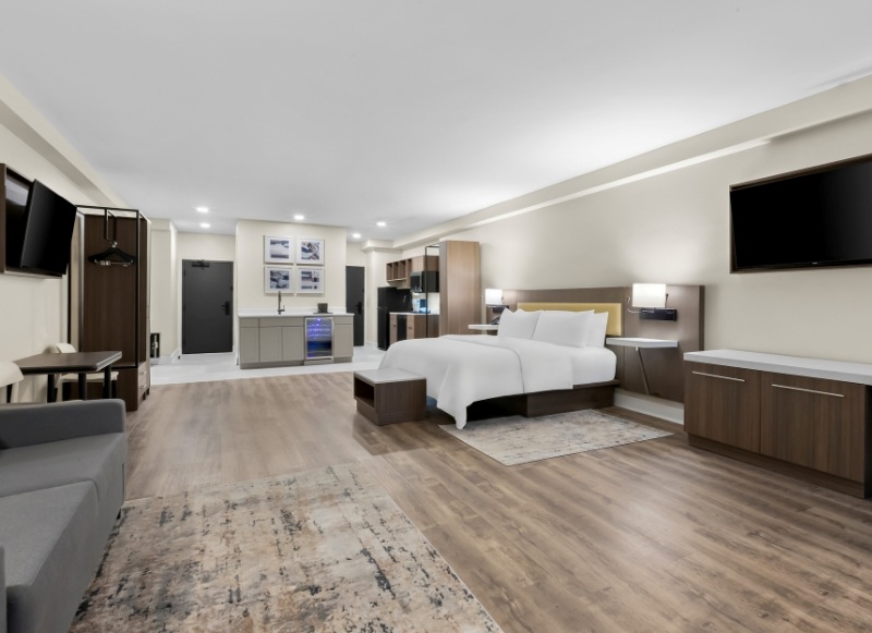 Hotel Tinton Falls NJ, featuring a couch, television, and a bed for comfortable accommodations.