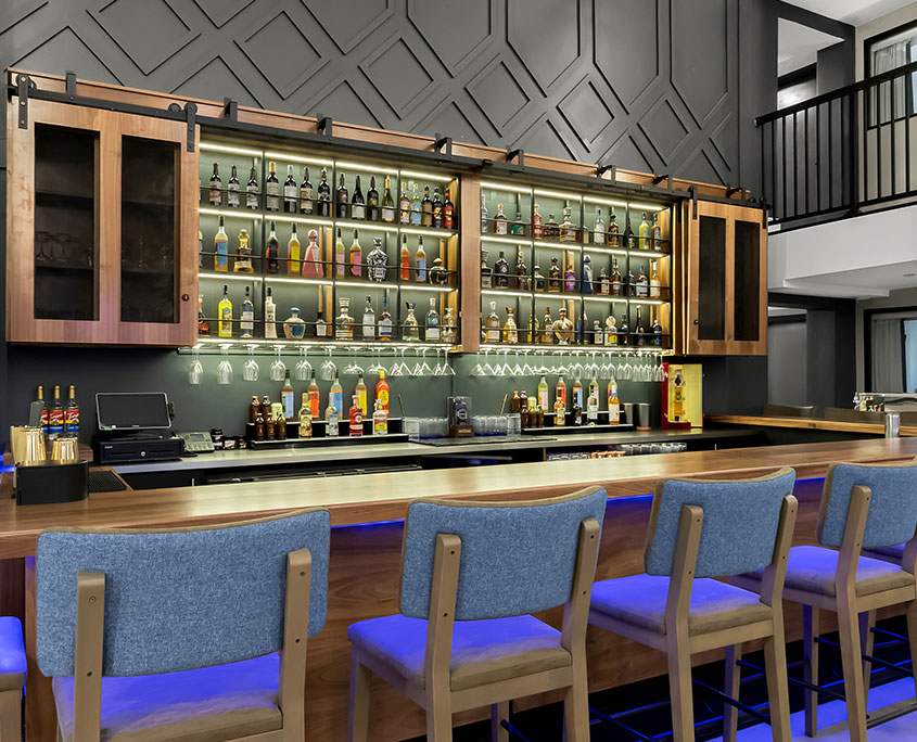 This image showcases the on-site bar at Latitude Suites, offering a relaxed yet upscale environment where guests can unwind with drinks after a long day.