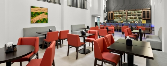 A restaurant interior featuring red chairs and tables, part of the Hotel Near Park Loft dining area.