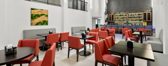 Dining area with red chairs and tables in a restaurant at the Hotel Near Shadowbrook at Shrewsbury