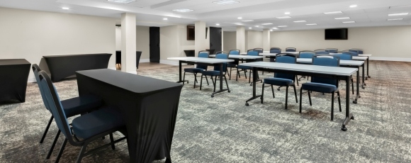 Conference room with tables and chairs, set for meetings at a hotel near Trump National Golf Club.