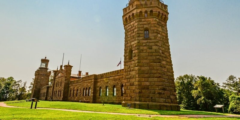 Historic Twin Lights Site in Tinton Falls, NJ, showcasing a large stone structure with an iconic clock tower.