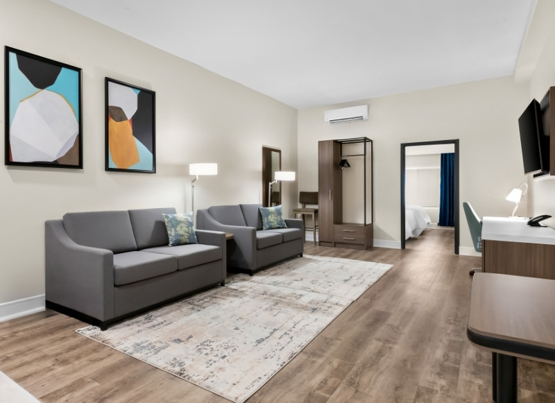 Spacious hotel suite with sofa seating, work desk, and modern amenities at Latitude Suites