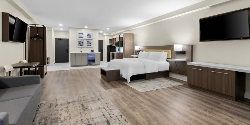 Stylish hotel room showcasing a bed, desk, and television, perfect for visitors at Latitude Suites.