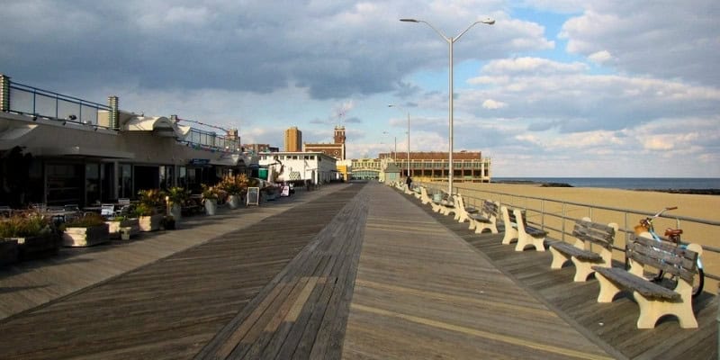 Asbury Park boardwalk showcasing a long pathway with benches and tables, perfect for unwinding and enjoy the view.