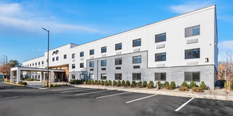 Latitude Suites exterior with on-site parking and front desk support for long-term stays