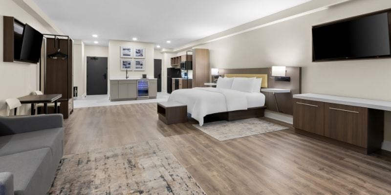 Spacious Latitude Suites room with bed, kitchenette and living area for long-term stays