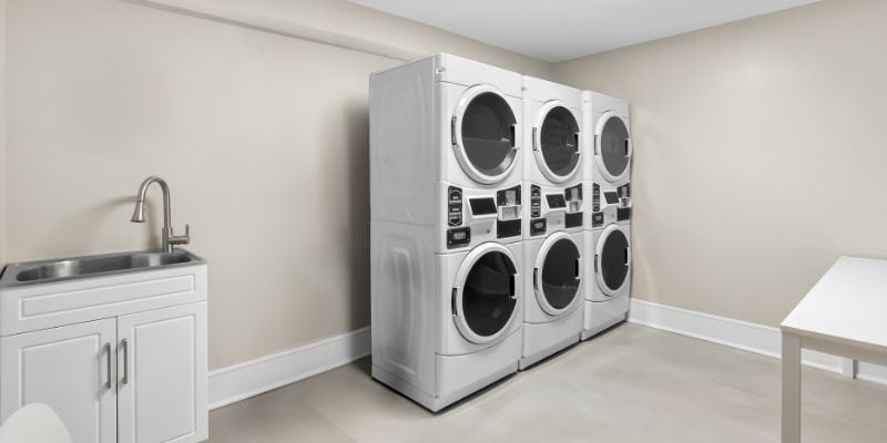 Guest laundry room at Latitude Suites near Tinton Falls with washers and dryers