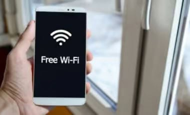 High-Speed WiFi Hand holding a smartphone displaying a Wi-Fi icon and the words "Free Wi-Fi" on screen.